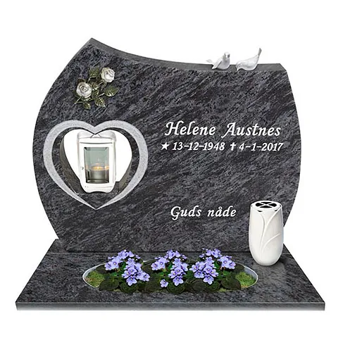 Mørk gravstein med hjerteformet lyktåpning, blomsterbed og teksten «Guds nåde».